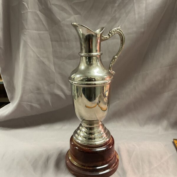 Antique silverplate claret jug golf trophy on wooden base.