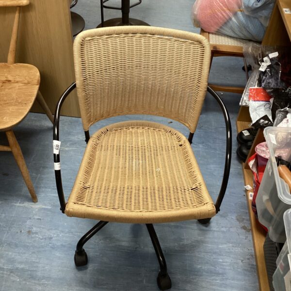 Vintage rattan office chair with black metal frame and casters.