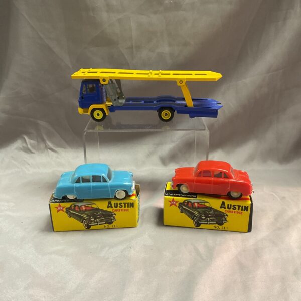 Vintage lot of Austin friction cars and Siku transporter toy vehicles.