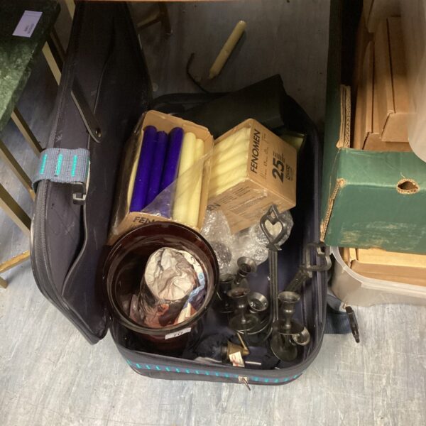 Vintage suitcase filled with a diverse lot of candles and holders.