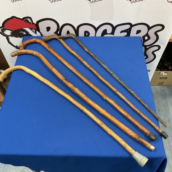 Bundle of vintage wooden walking sticks and antique canes.