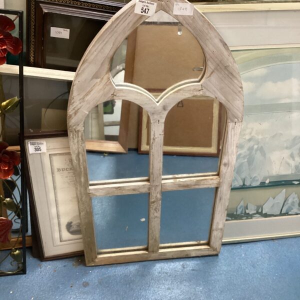 Antique gothic arched mirror with ornate wooden frame.