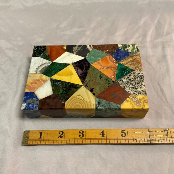Colourful mosaic stone trinket box with geometric design.