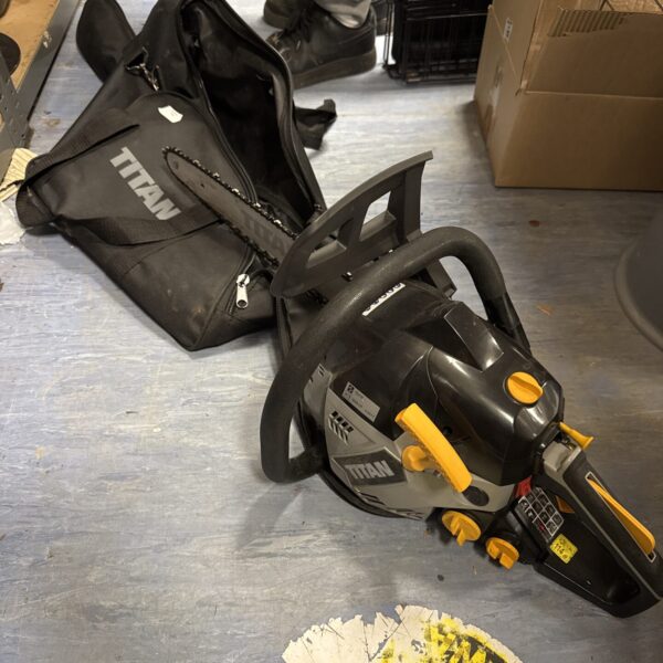Titan petrol chainsaw in its original carry case, ready for garden work.