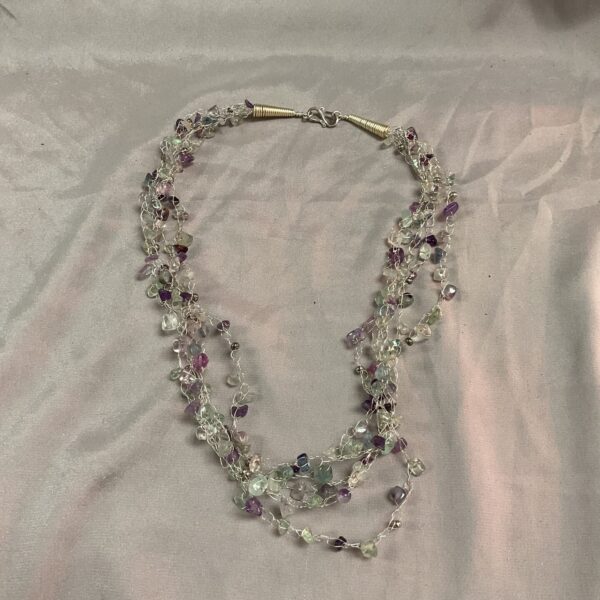 Multi-strand stone bead necklace with whitemetal accents.