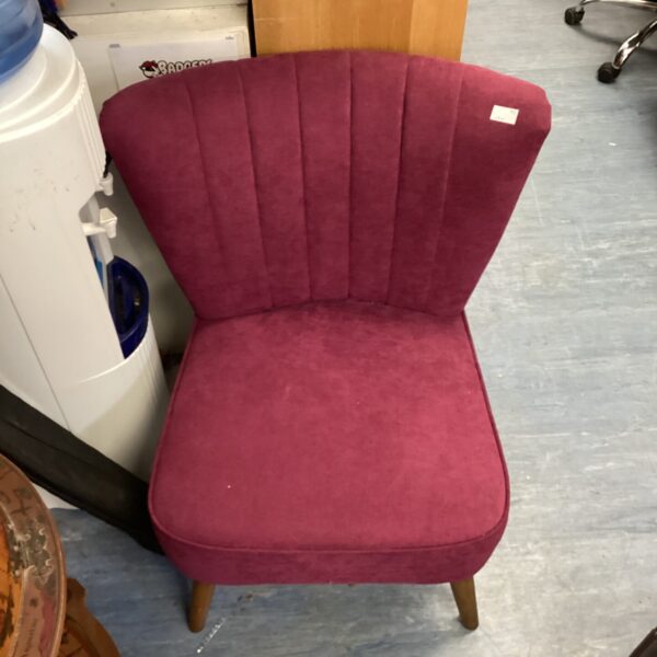 Vibrant purple mid-century nursing chair with wooden legs.