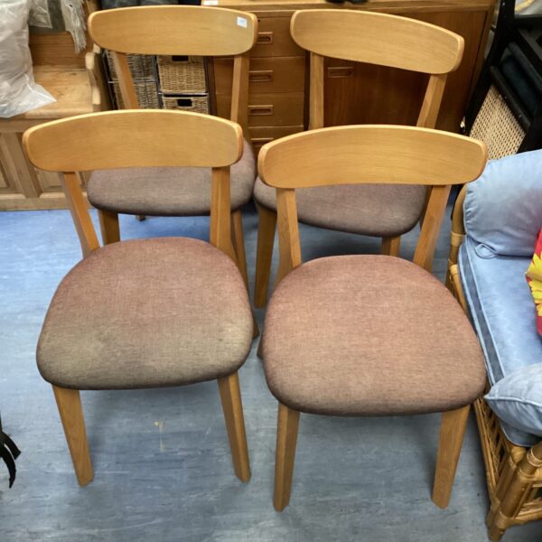 Set of four oak effect dining room chairs.