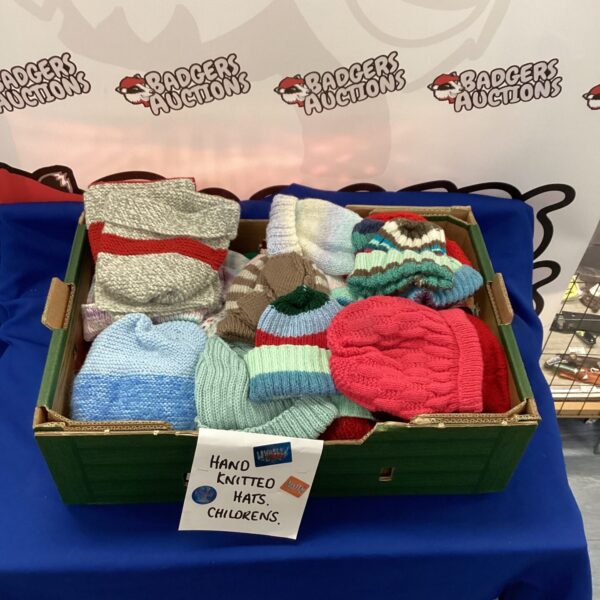 Tray of colourful hand knitted childrens hats for winter.