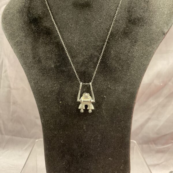 Vintage silver pendant necklace with girl on swing charm.