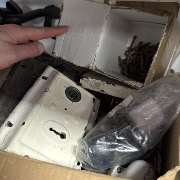 Vintage door locks and keys in a cardboard box.