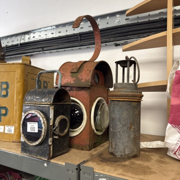 Vintage railway lantern showing side view and protective cage.