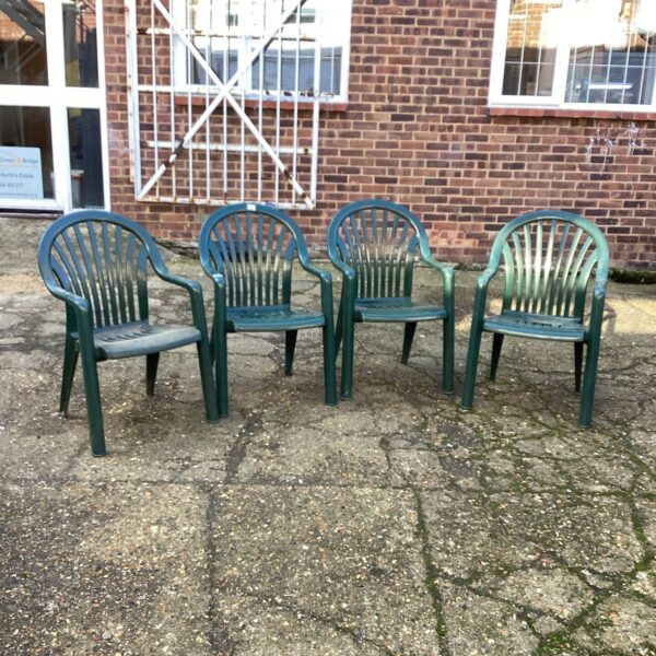 Lot of four plastic stacking garden chairs for outdoor use.