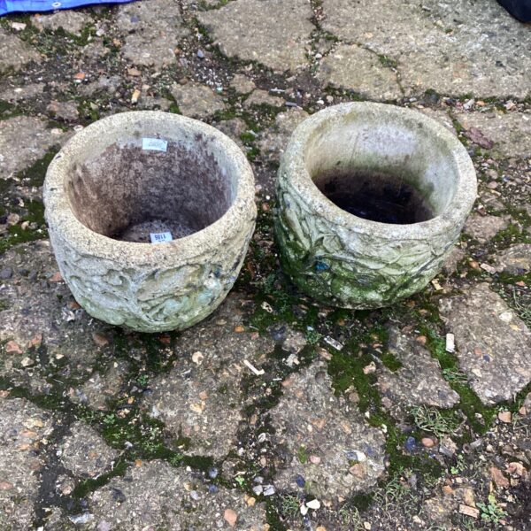 Pair of weathered stone effect garden planters for outdoor use.