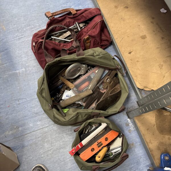 Assortment of vintage tool bags for workshop storage.
