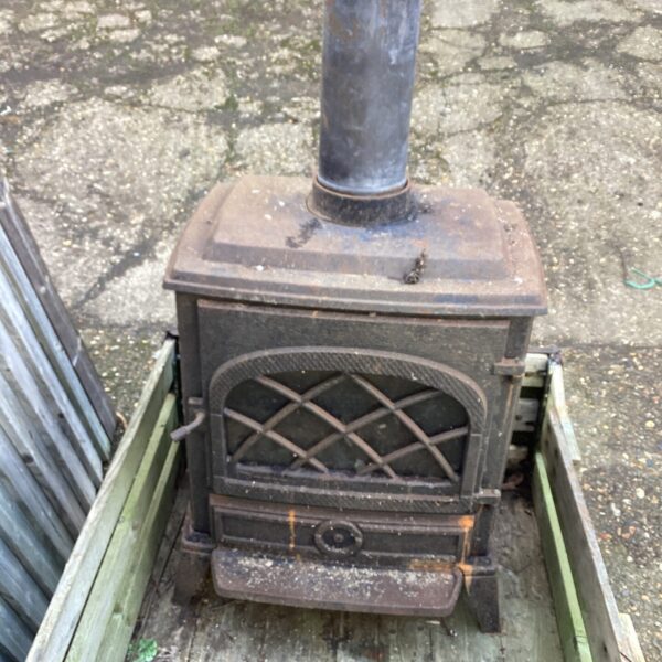 Antique wrought iron wood burning stove with detailed door.