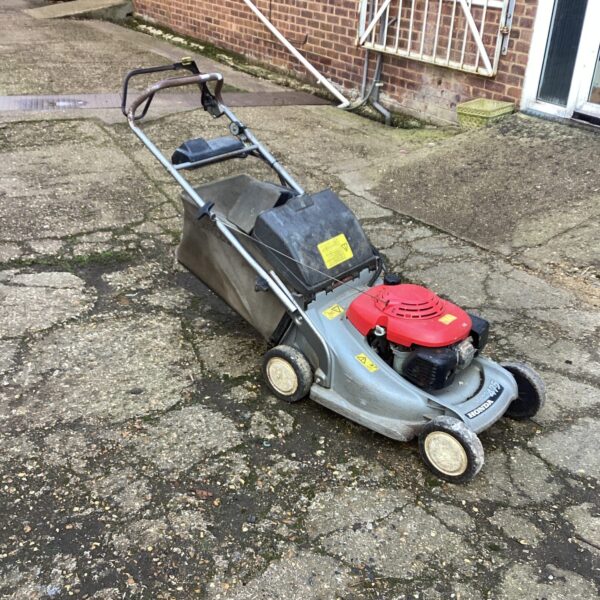 Used Honda 475 lawn mower in a garden setting.