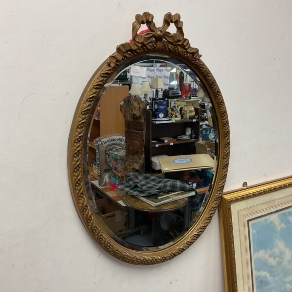 Ornate gilt framed bevelled mirror in vintage condition.