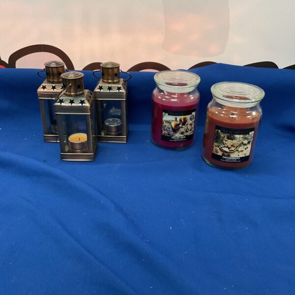 Decorative candle holders and scented candles in a lot.