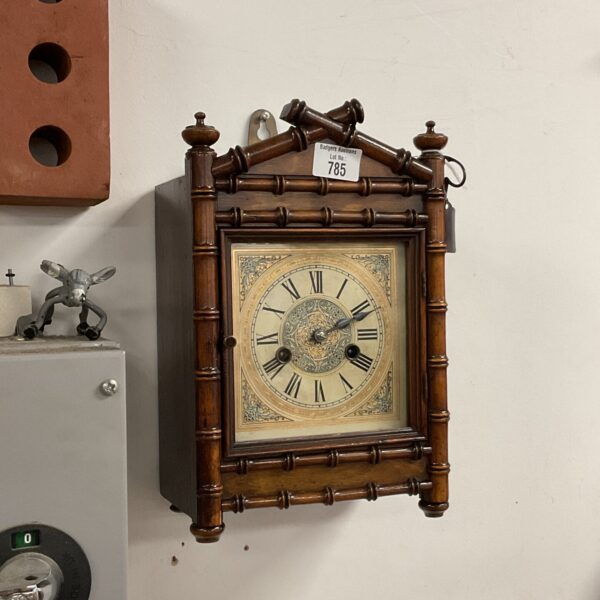 Antique H A C wall clock with painted face and Roman numerals.
