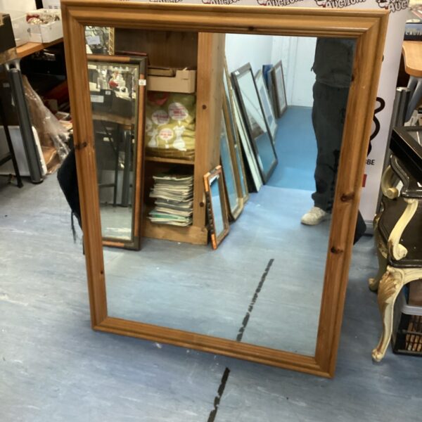 Large pine framed mirror with a rustic aesthetic.