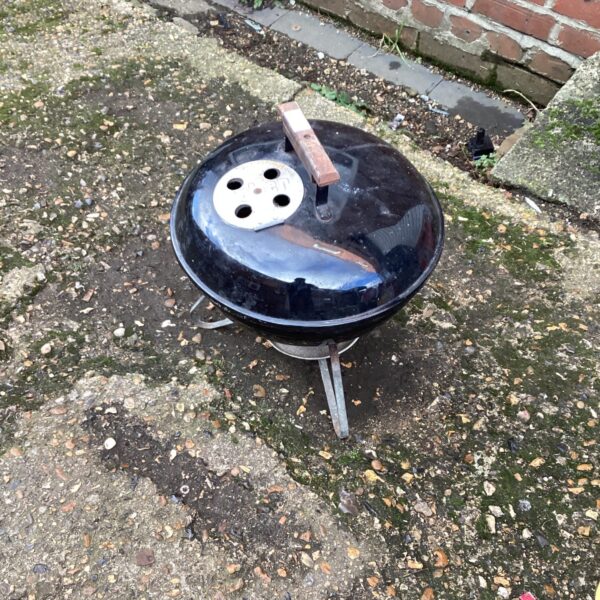 Vintage Weber BBQ grill showing signs of wear.