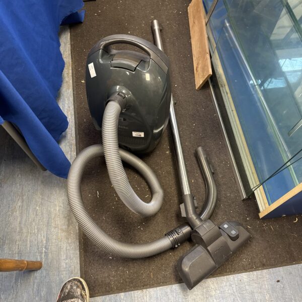 Miele S2111 compact cylinder vacuum cleaner in a home setting.