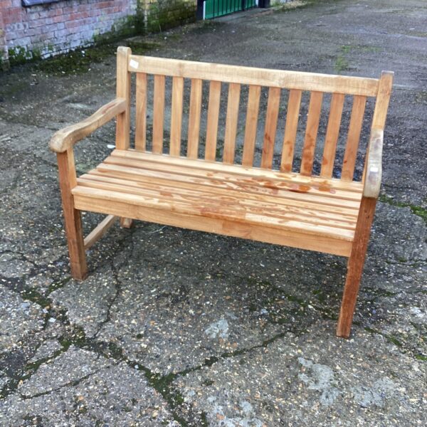 Classic teak garden bench in a garden setting.