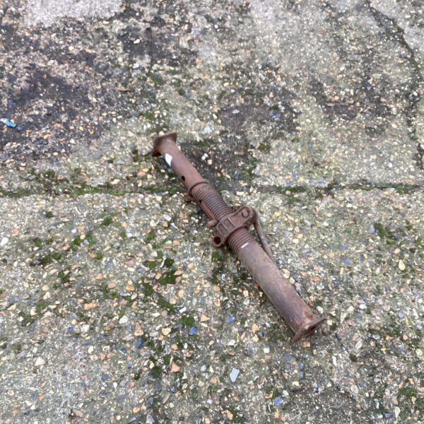Rusty metal adjustable acro prop for construction support.