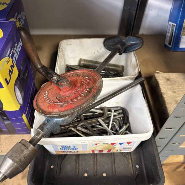 Vintage drill brace with wooden handle and metal chuck.