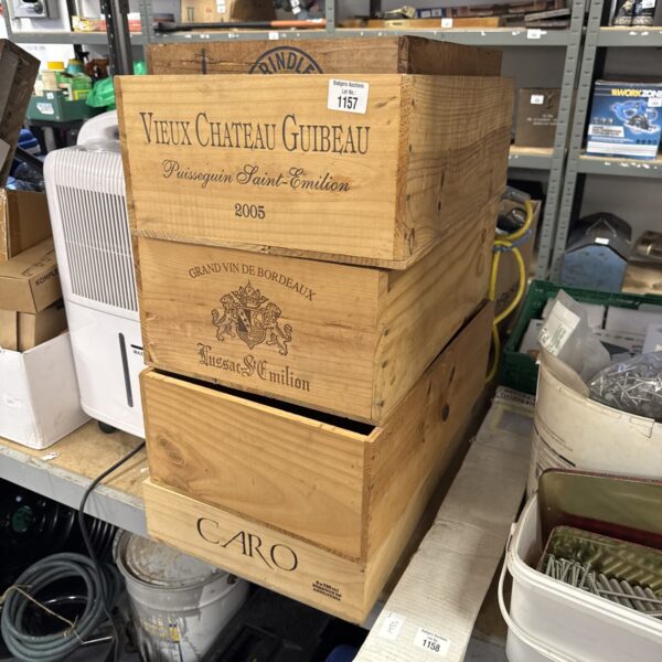 Stack of vintage wooden wine boxes with vineyard names.