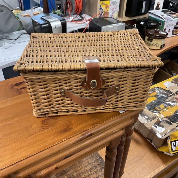 Small vintage wicker basket with a handle, ideal for storage.