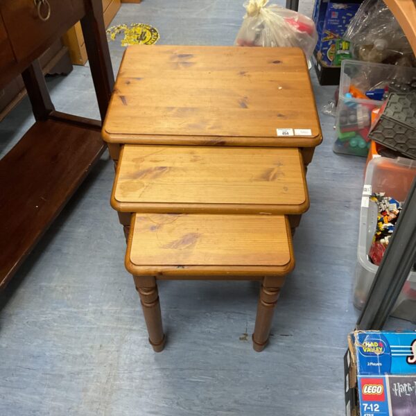 Vintage pine nest of three tables in a warm, rustic style.