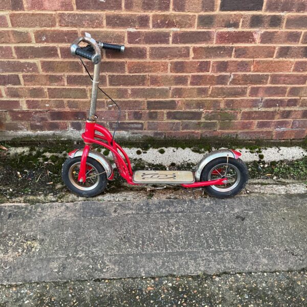Red vintage Powerlite childrens scooter, classic retro outdoor toy.