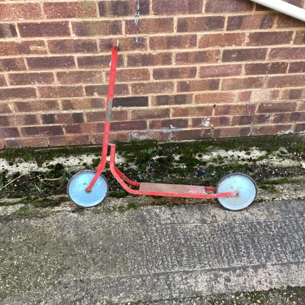 Red vintage childs scooter, a classic metal ride on toy.