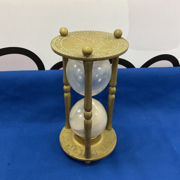 Large brass hourglass with angel relief, decorative timepiece.