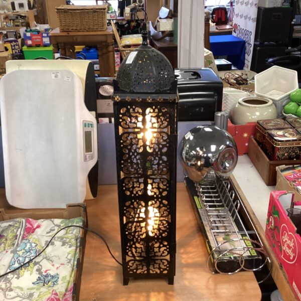Intricate pierced metal table lamp with warm lighting.