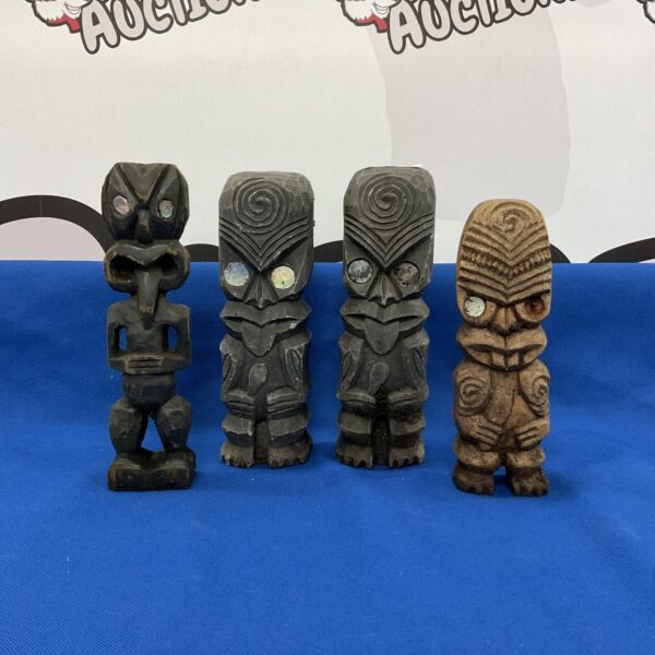 Set of four miniature carved wood and stone totem poles.