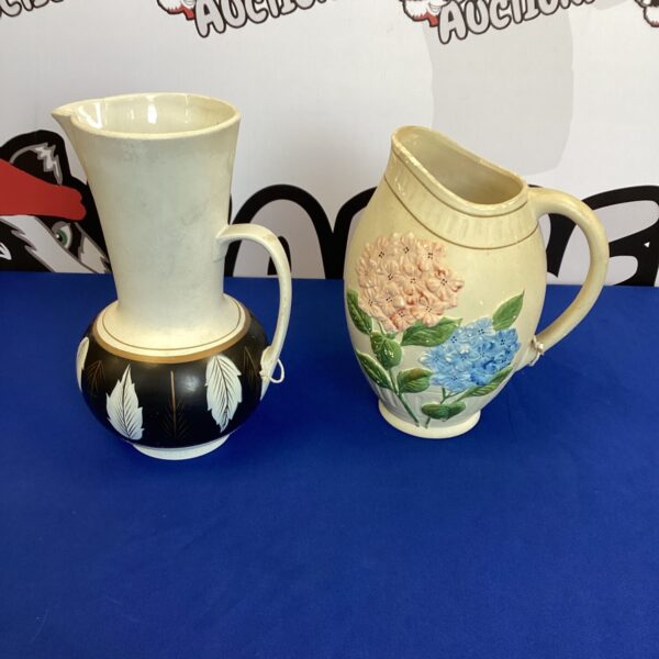 Pair of vintage Polish pottery jugs with floral details.