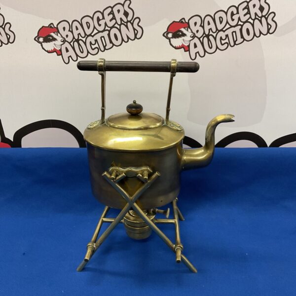 Vintage brass spirit kettle with tripod base for camping.