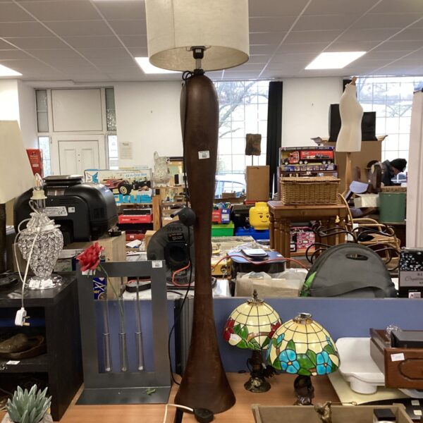Vintage wooden standard lamp with cream lampshade for home lighting.