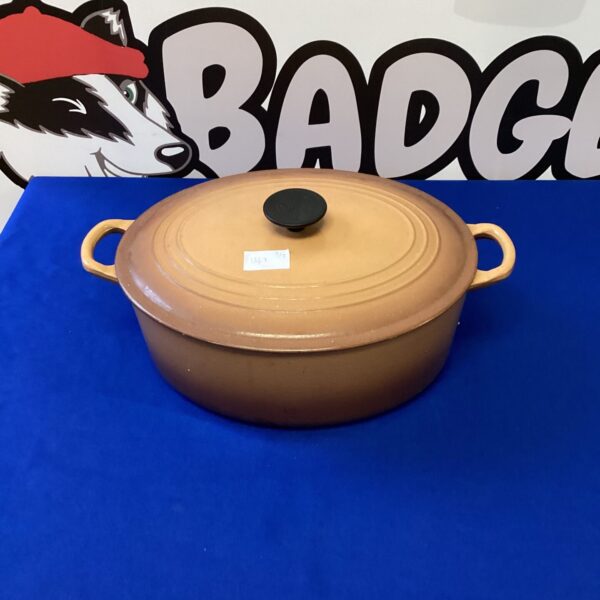 Vintage Le Creuset casserole pot in vibrant orange enamel.