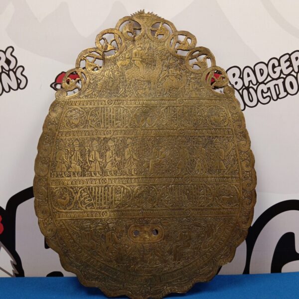Intricate engraved Indian brass wall plaque with floral designs.