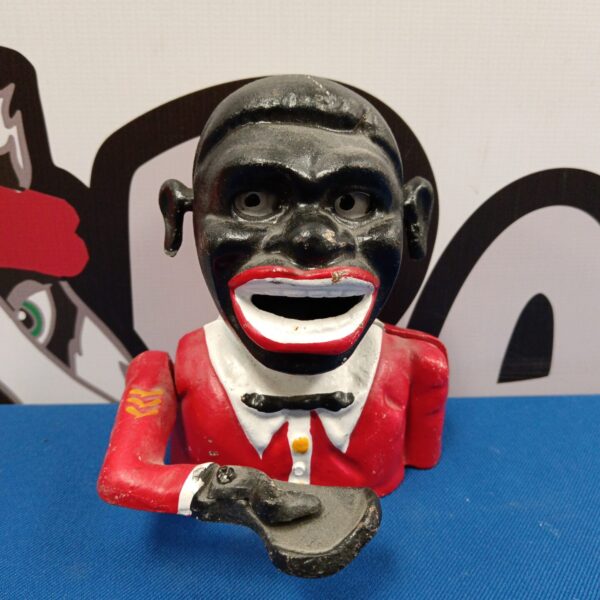 Antique cast iron moneybox featuring a gentleman in red.