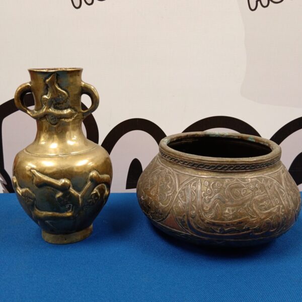 Antique oriental brass vase and copper bowl on display.