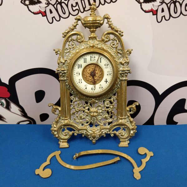 Ornate brass French mantle clock with Roman numeral dial.