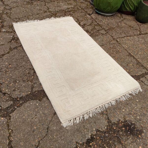 Cream rug with a subtle geometric pattern for home decor.