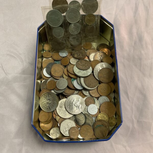 Metal tin filled with a diverse assortment of vintage coins.