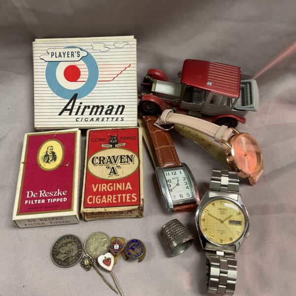 Mixed vintage lot featuring a Seiko watch, cigarette packets and badges.