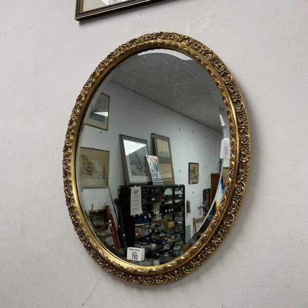Antique gilt framed oval mirror with bevelled edge.