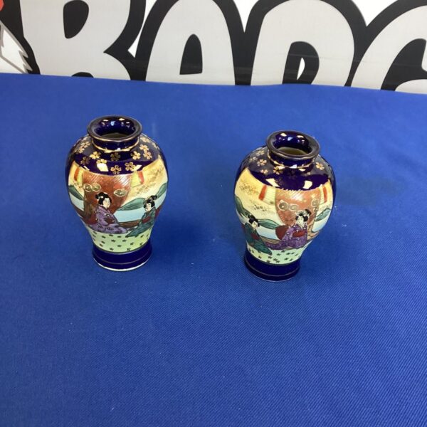Antique Japanese Satsuma vases with detailed hand-painted scenes.